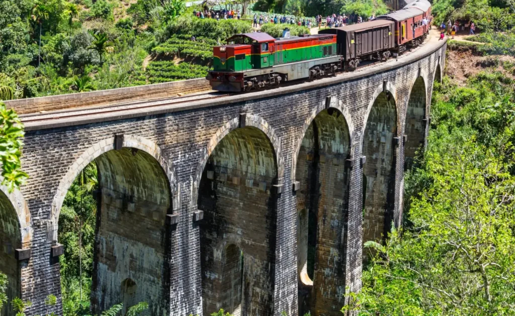 Train crossing the Nine Arch Bridge surrounded by jungle near Ella, Sri Lanka